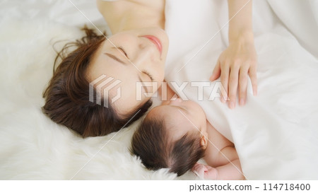 A mother co-sleeping with her one-month-old son A mother co-sleeping with her one-month-old son 114718400