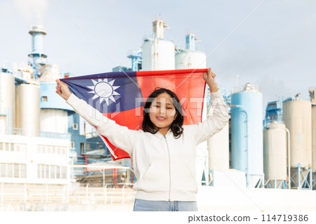 Happy asian girl with flag of taiwan standing in front of industrial scenery 114719386