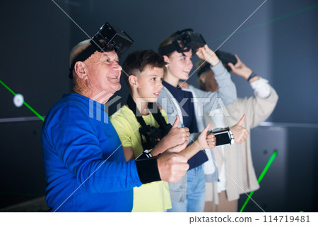 Family are wearing virtual reality goggles in quest room 114719481