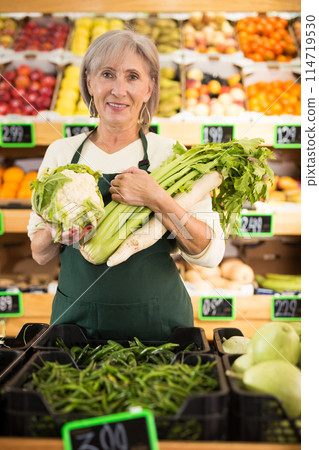 Mature lady supermarket worker with vegetables in hands 114719530