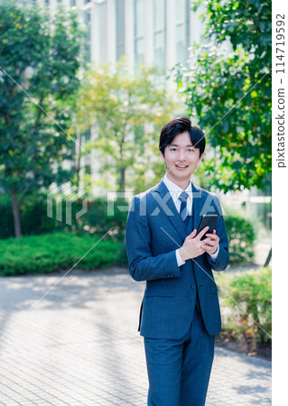 使用智慧型手機的清爽商人 使用智慧型手機的清爽商人 114719592