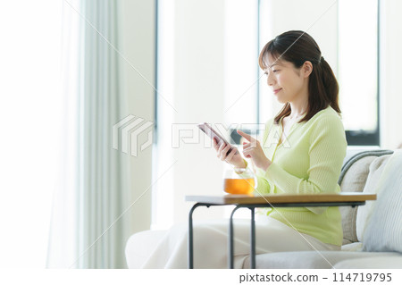 A woman watching a smartphone A woman watching a smartphone 114719795