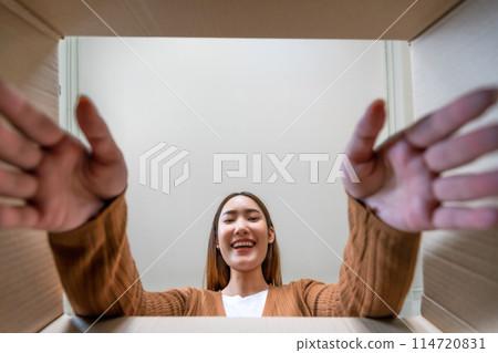 Low angle view of surprised young asian woman unpacking Low angle view of surprised young asian woman unpacking 114720831