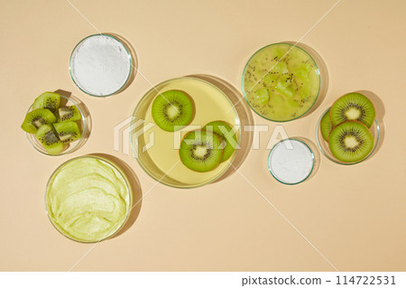 Plenty glass dishes displayed on light yellow counter top, a blank dish in center with some kiwi slices above, next to it are some dishes of exfoliating cream and fresh kiwi. Template for designing Plenty glass dishes displayed on light yellow counter top, a blank dish in center with some kiwi slices above, next to it are some dishes of exfoliating cream and fresh kiwi. Template for designing 114722531