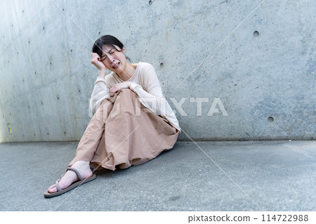 靠牆坐著的年輕女子 114722988