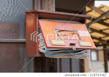 Old mailbox overflowing with mail 114723387