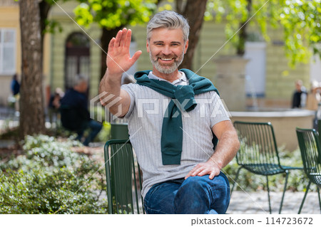 Mature man tourist smiling at camera waving hands gesturing invitation hello hi greeting goodbye 114723672