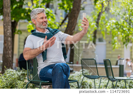 Mature man blogger use smartphone communicating video call online with subscribers recording stories Mature man blogger use smartphone communicating video call online with subscribers recording stories 114723691