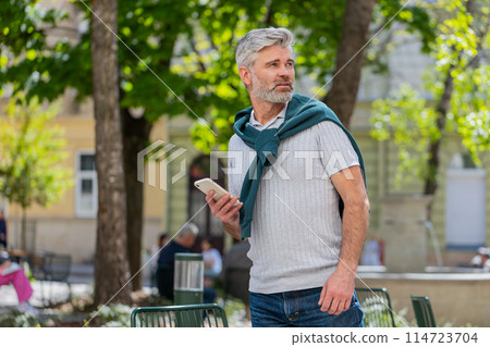 Tourist mature man using smartphone text messages looking for search a way on map in navigator app 114723704