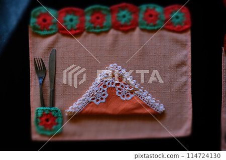 tiltshift of a colorful crochet embroidered dining tablecloth 114724130
