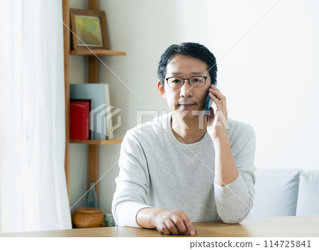Middle-aged man talking on smartphone Middle-aged man talking on smartphone 114725841