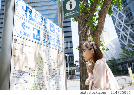 A woman looking at an area map 114725995