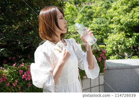 A woman drinking water of a plastic bottle A woman drinking water of a plastic bottle 114726039