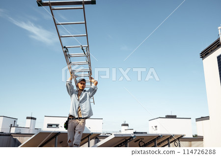Man carries ladder during solar panels installation 114726288