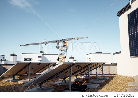 Man carries ladder during solar panels installation 114726292