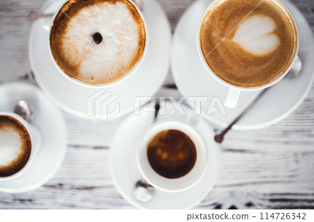 Cups with hot espresso, cappuccino, latte on table. Cups with hot espresso, cappuccino, latte on table. 114726342