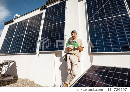Technician with a digital tablet on a rooftop with solar power station Technician with a digital tablet on a rooftop with solar power station 114726597