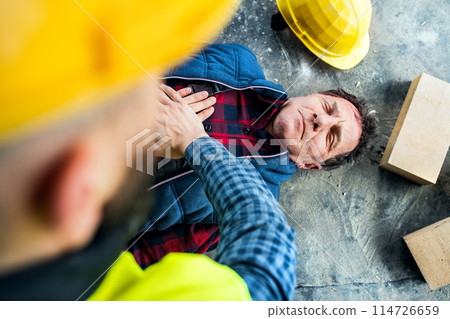 Colleague performing CPR on an injured worker lying on the ground after accident. Concept of occupational safety and health in workplace. Colleague performing CPR on an injured worker lying on the ground after accident. Concept of occupational safety and health in workplace. 114726659
