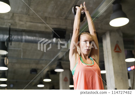 Beautiful sport woman exercising with kettlebell. Routine workout for woman's physical and mental health. Beautiful sport woman exercising with kettlebell. Routine workout for woman's physical and mental health. 114727482