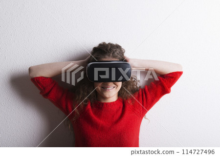 Young teenage girl with VR headset. Virutal reality, VR technology. Studio shot on white background with copy space. 114727496
