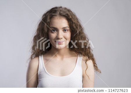 Portrait of a gorgeous teenage girl with curly hair. Studio shot, white background with copy space Portrait of a gorgeous teenage girl with curly hair. Studio shot, white background with copy space 114727623