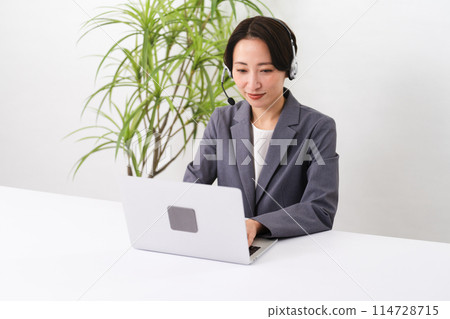 Young female operator operating a personal computer Business image 114728715