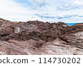A rock jutting out from a rocky area 114730202