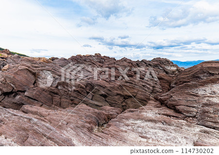 A rock jutting out from a rocky area A rock jutting out from a rocky area 114730202
