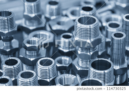 The pile of steel water pipe connector parts in the light blue scene. 114730325