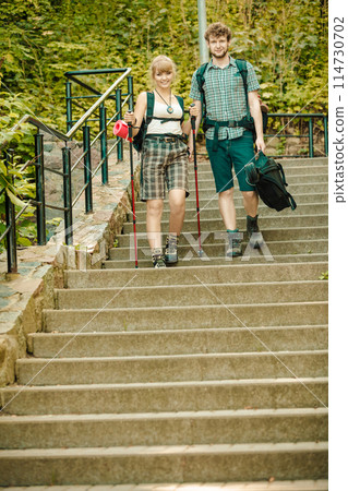 Two people tourists hiking walking on stairs. 114730702