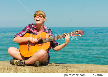 Young woman with guitar outdoor Young woman with guitar outdoor 114730823