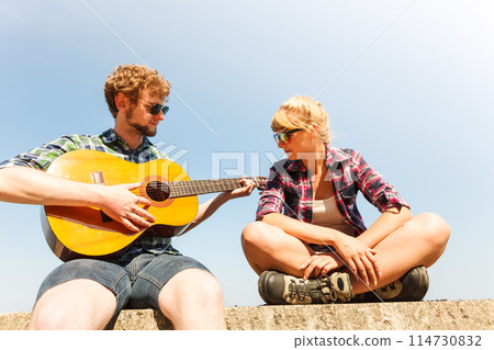 Young man hipster playing guitar for woman. Young man hipster playing guitar for woman. 114730832