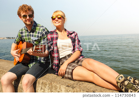 Young man hipster playing guitar for woman. 114730843