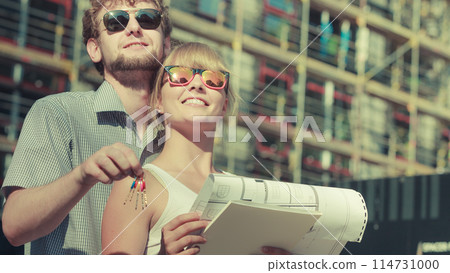 Couple on front of new house with blueprint project Couple on front of new house with blueprint project 114731000