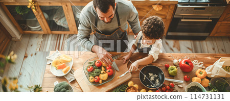 Father and son cooking dinner together on the domestic kitchen. Family and parenting concept. 114731131