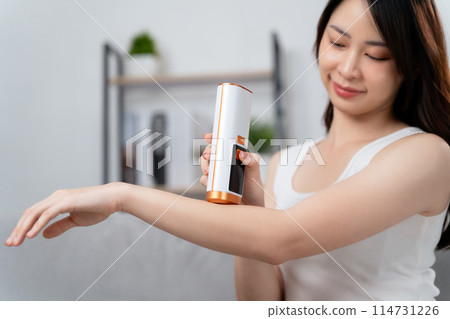 A beautiful woman is epilating and removing hair using an IPL laser hair removal epilator device. 114731226