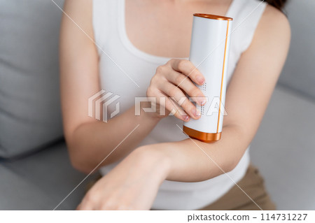 A beautiful woman is epilating and removing hair using an IPL laser hair removal epilator device. 114731227