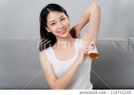 A beautiful woman is epilating her armpits using an IPL laser hair removal epilator device. 114731230