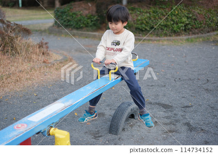 Boy playing with seesaw 114734152