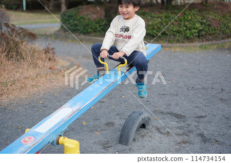 Boy playing with seesaw 114734154