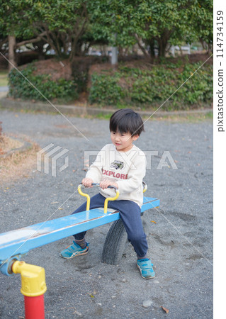 Boy playing with seesaw 114734159
