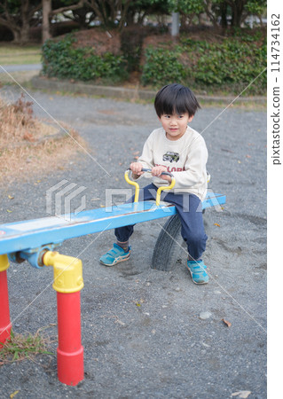 Boy playing with seesaw 114734162