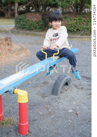 Boy playing with seesaw 114734164