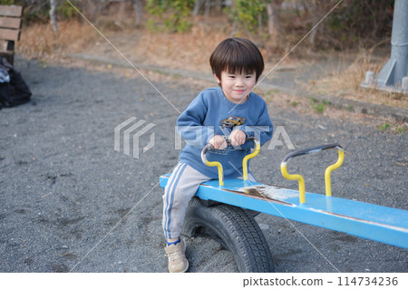 Boy playing with seesaw 114734236