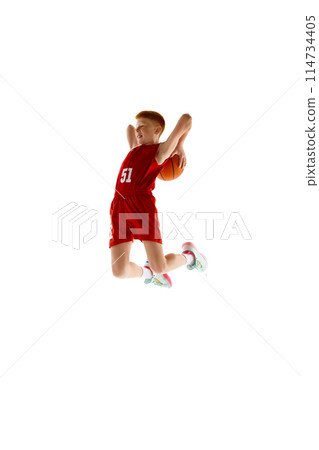 Full-length dynamic image of teen boy in red uniform, playing basketball, throwing all in jump isolated on white studio background 114734405