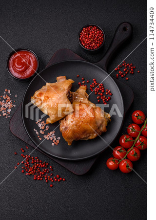 Delicious juicy chicken thighs baked on the grill with salt Delicious juicy chicken thighs baked on the grill with salt 114734409