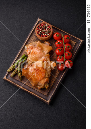 Delicious juicy chicken thighs baked on the grill with salt Delicious juicy chicken thighs baked on the grill with salt 114734412