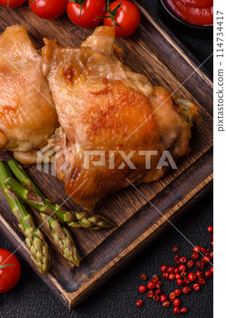 Delicious juicy chicken thighs baked on the grill with salt Delicious juicy chicken thighs baked on the grill with salt 114734417