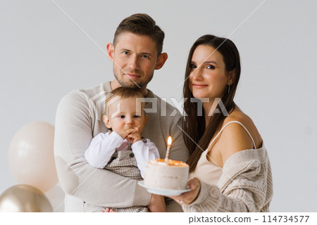 Happy parents mom and dad with their son celebrate birthday with cake and balloons Happy parents mom and dad with their son celebrate birthday with cake and balloons 114734577