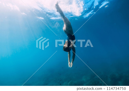 Woman swims in clear sea. Freediving and beautiful lady in ocean 114734750